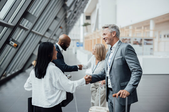 Business partners shake hands at the airport terminal