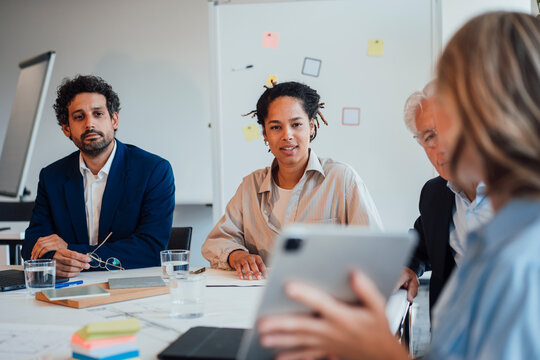 Diverse business team listens to presentation in office
