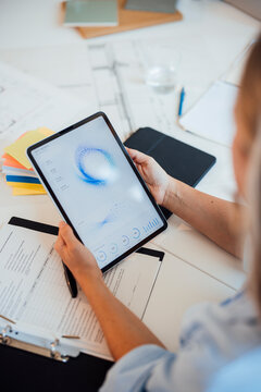 Architect analyzing statistics on digital tablet at office desk