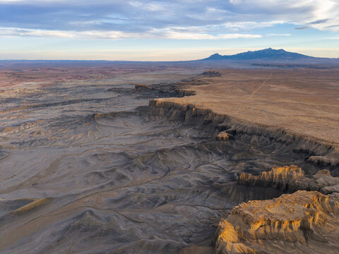Aerial view of Moonscape Overlook near Hanksville, Utah, with deeply eroded badlands in the foreground and the Henry Mountains rising in the distance.
