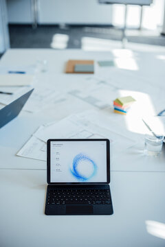 A digital tablet displays business statistics on a meeting room desk