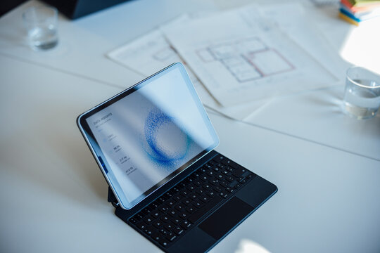 A digital tablet displays statistics on a desk in a meeting room