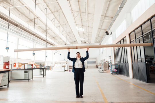 Smiling businesswoman holds wood in a carpentry workshop