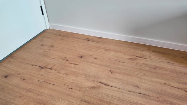 Natural wood laminate parquet floor. Room with laminate in new apartmen. Cozy home interior, modern design
