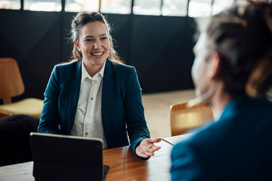 A businesswoman talks to a businessman at the office desk