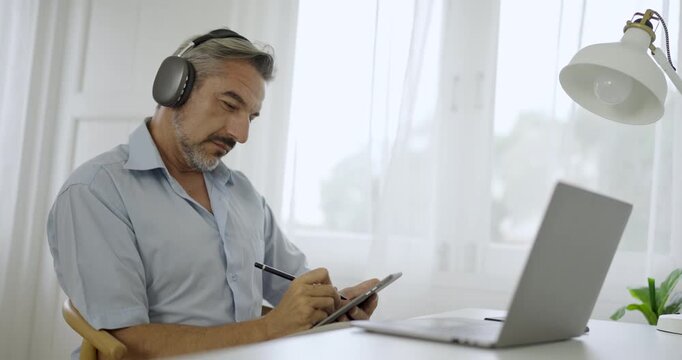 Portrait of happy caucasian business senior man casual cloths shirt work in home office desk using head phone computer. Small business employee freelance online sme marketing e-commerce telemarket