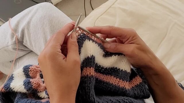 Hands Knitting Striped Wool Fabric with Knitting Needles