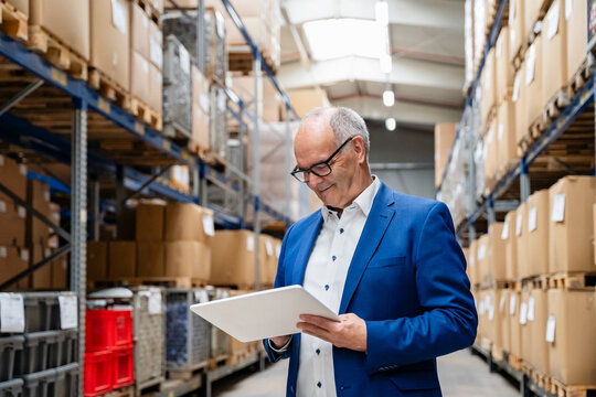 Manager uses tablet for logistics planning in warehouse