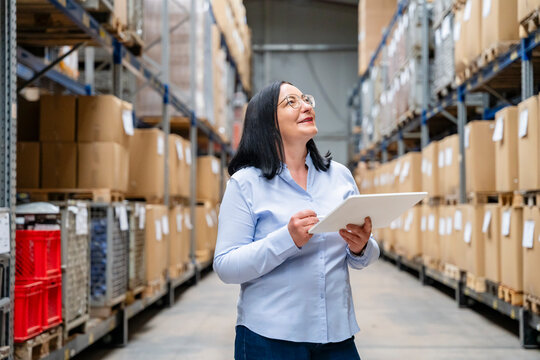 Woman checks inventory with a tablet in the warehouse