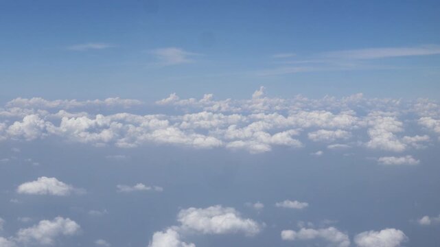 blue sky with white fluffy clouds from airplane flight fly over the clouds in a sunny day with cloud moving in summer, summer cloudscape background