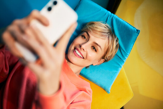 A smiling woman takes a selfie during a break at the office