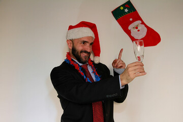 Fototapeta premium Trabajador brindis y traje celebrando Navidad y Nochevieja gorro de Papa Noel autónomo vestido de Santa Claus y fiesta fin de año con copa champán businessman christmas party celebración Nochebuena 