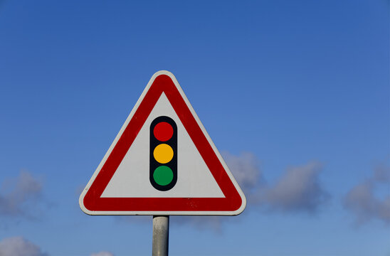 Traffic light warning sign against blue sky