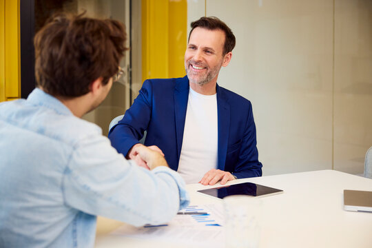 Businessman shaking hands during a job interview at the office
