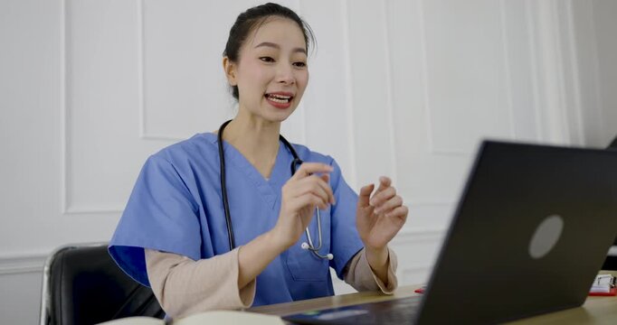 Female asian doctor using laptop for online live speak consultation in a medical office, representing telemedicine, healthcare communication, and virtual patient clinic
