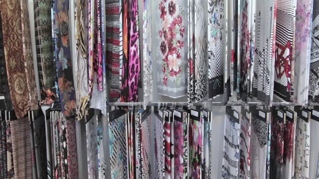 Rows of Patterned Fabric Rolls Displayed in a Textile Store. The footage documents textile equipment, material handling, stitching or machine controls in a workshop.