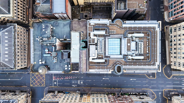 Aerial view of a city block featuring rooftops, a central glass atrium, and surrounding streets in Glasgow, Scotland, United Kingdom.