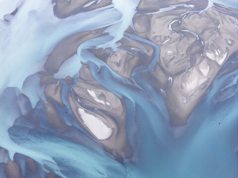 Aerial view of the braided channels of the Knik River with silt-laden glacial water flowing through the landscape in Knik River, Alaska, United States.