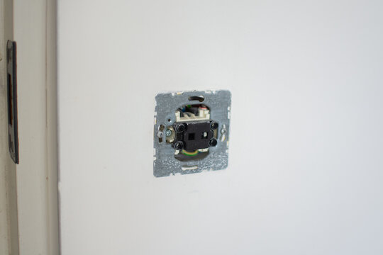 Close-up of an unfinished electrical installation showing the internal mechanism of a light switch