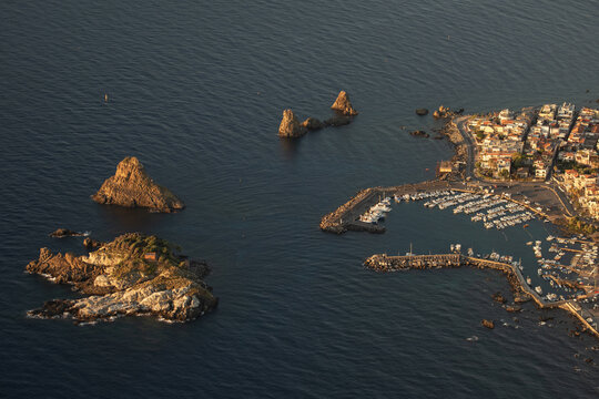 Aerial view of the volcanic Cyclops Islands and the marina in Aci Trezza, Catania, Sicily, Italy.