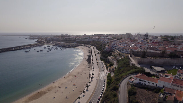 Aerial view of the coastal town of Sines with its sandy beach, harbor, and historic buildings along the coastline in Sines, Setubal, Portugal.