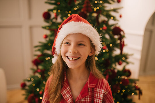 Cute 7-years old girl portrait near decorated Christmas tree.
