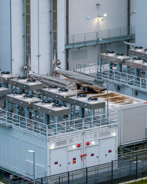 Aerial view of advanced backup power generators for an AI data center, featuring industrial cooling units and metallic exhaust pipes in Warszawa, Masovian Voivodeship, Poland.