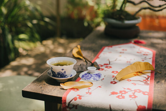 Chinese jasmin tea on a wooden table in a yard.