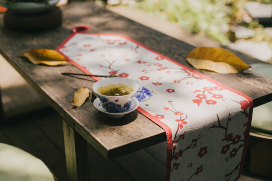 Chinese jasmin tea on a wooden table in a yard.