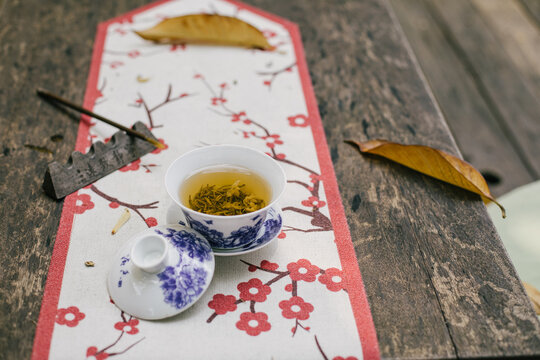 Chinese jasmin tea on a wooden table in a yard.