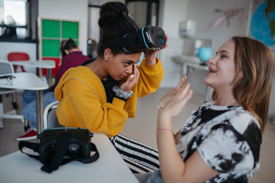 High school student using virtual reality for immersive learning in classroom.