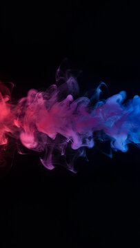 Abstract red blue and purple ink clouds swirling in clear water on a black background with abstract background creative colorful artistic backdrop movement gradient composition