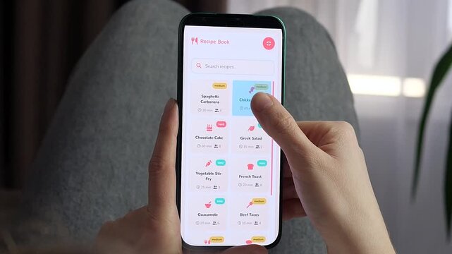 Person selects a chicken curry recipe in a mobile cooking app, revealing ingredients and prep details as digital meal planning makes home cooking faster and easier.