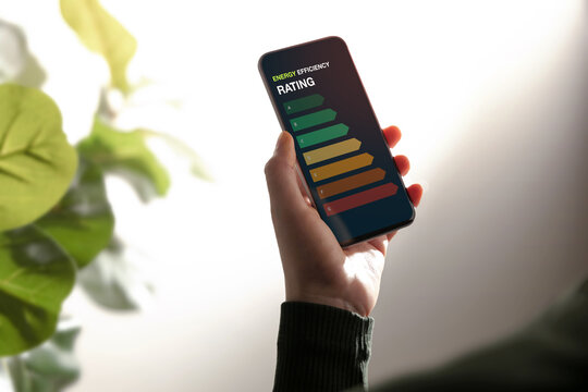 Hand holds a smartphone displaying an energy rating scale