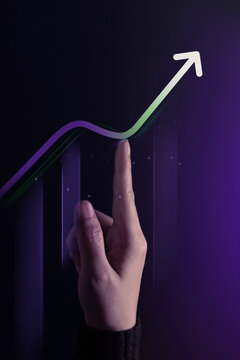 Hand points toward a rising illuminated graph and arrow
