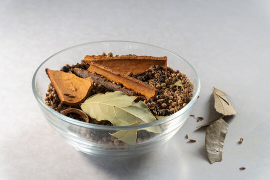 Whole aromatic spices for making garam masala in glass bowl