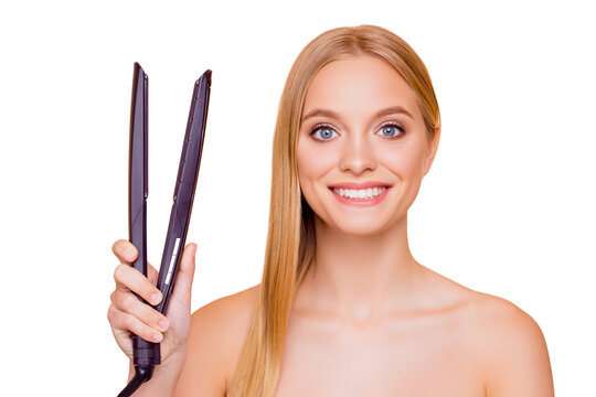 Portrait of cheerful positive joyful model with clean clear fresh skin beaming smile having straightener in hand looking at camera isolated on beige background