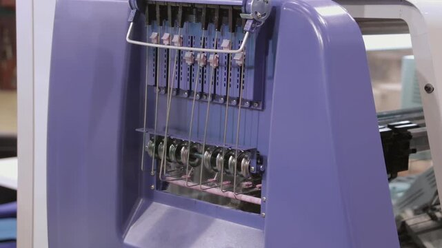Close View of Needles and Guides on a Knitting Machine. The footage documents textile equipment, material handling, stitching or machine controls in a workshop.