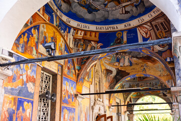 Fototapeta premium Colorful frescoes decorating arches and walls of St. Joachim Church at Osogovo Monastery in North Macedonia, depicting biblical scenes and saints in Byzantine style