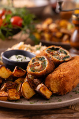Pork chop rolls stuffed with spinach and mozzarella. Served with sun-dried tomatoes and roasted potatoes. © gkrphoto