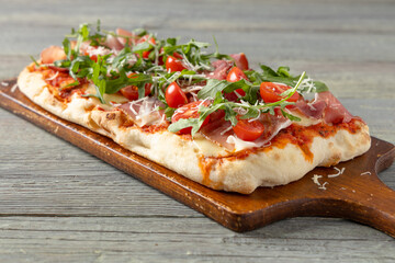Traditional pinsa with Parma ham, fresh cherry tomatoes and arugula © gkrphoto