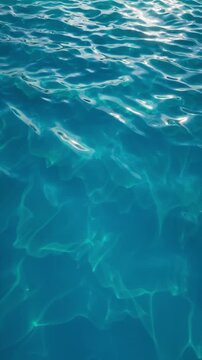 Tall blue water waves shimmer with soft caustic reflections. Clean vertical loop for mobile screens, promos, and summer visuals. Vertical 3d render video.