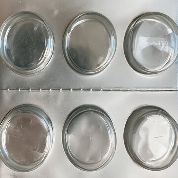Empty pharmaceutical pill blister pack with silver foil cavities, close-up medicine packaging background