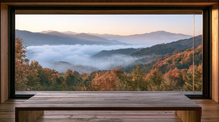 Fototapeta premium panoramic window view of mountain landscape covered with autumn fog sea of clouds bright fall forest trees and low wooden table in cozy modern cabin room peaceful scenic morning view