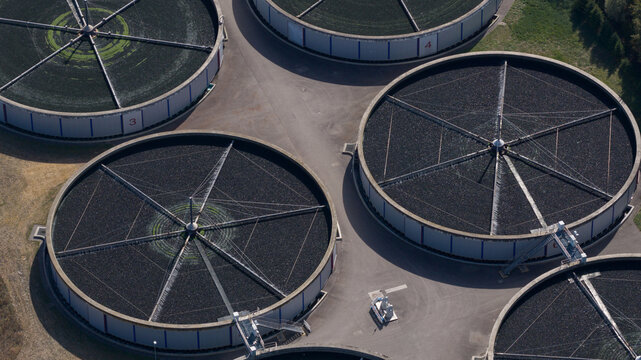 Aerial view of circular wastewater treatment tanks and clarifiers at a water treatment facility in Karlsruhe, Baden-Wurttemberg, Germany.