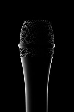 Microphone silhouette creating dramatic atmosphere on black background