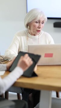Elderly businesswoman, senior manager, work on laptop in a modern company office . High quality 4k footage