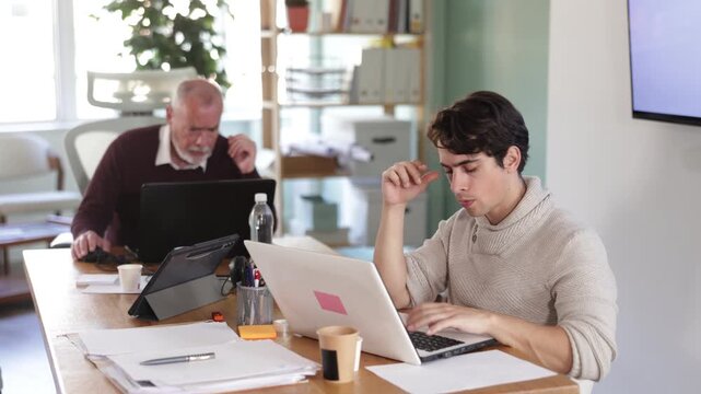 Frustrated and discouraged men in front of laptop in office workplace. Negative consequences, disappointing news, loss, fine, or family disaster. 