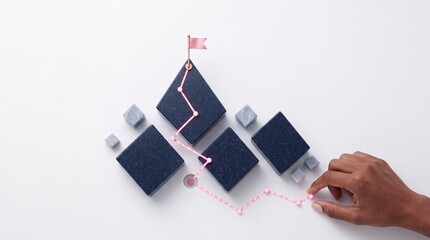 Fototapeta premium Top down overhead view of a hand mapping out a glowing strategic path with neon lines and marble blocks leading to a success flag on a white background, symbolizing business growth and goals
