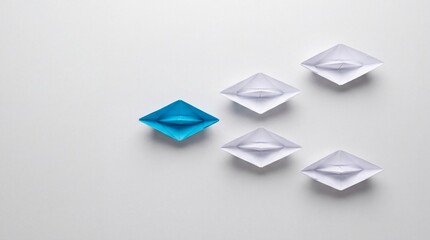 Fototapeta premium Top View of a Single Blue Paper Boat Leading a Group of White Origami Boats on a Clean Surface, Representing Leadership, Business Strategy, Innovation, and Teamwork Success Concept.